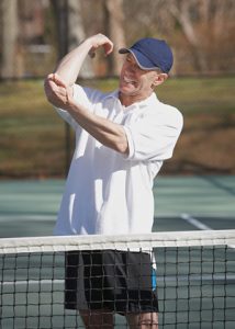 Tennis player holding his elbow due to pain