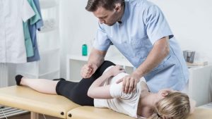 A woman with blonde hair having a lower back pain massage