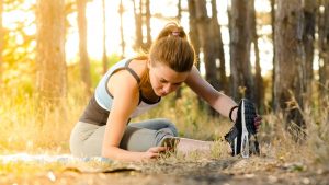 athlete stretching on the woods