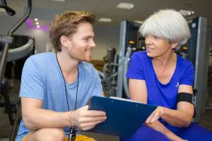 physical therapist in discussion with a senior female patient