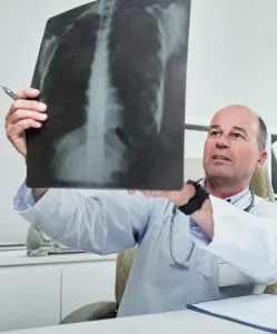 chiropractor looking at a patient back x-ray