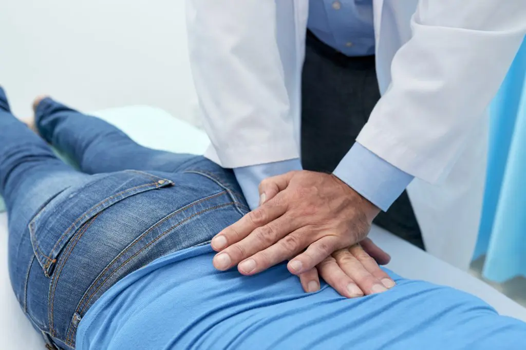 chiropractor adjusting patients back 