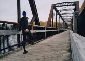 Runner stretching before a run on a bridge