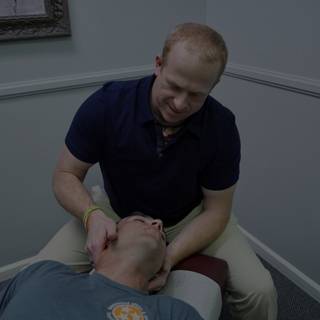 chiropractor adjusting a male patient on a drop table