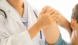 close up chiropractor working with patient elbow condition