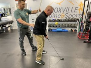 physical therapist correcting stance of a golfer patient