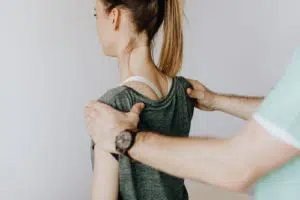 chiropractor guiding a patient to straighten her back 