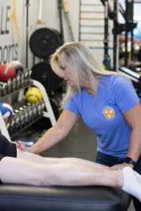 female physical therapist massaging the back of a patient's leg