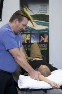 chiropractor adjusting a patients shoulder