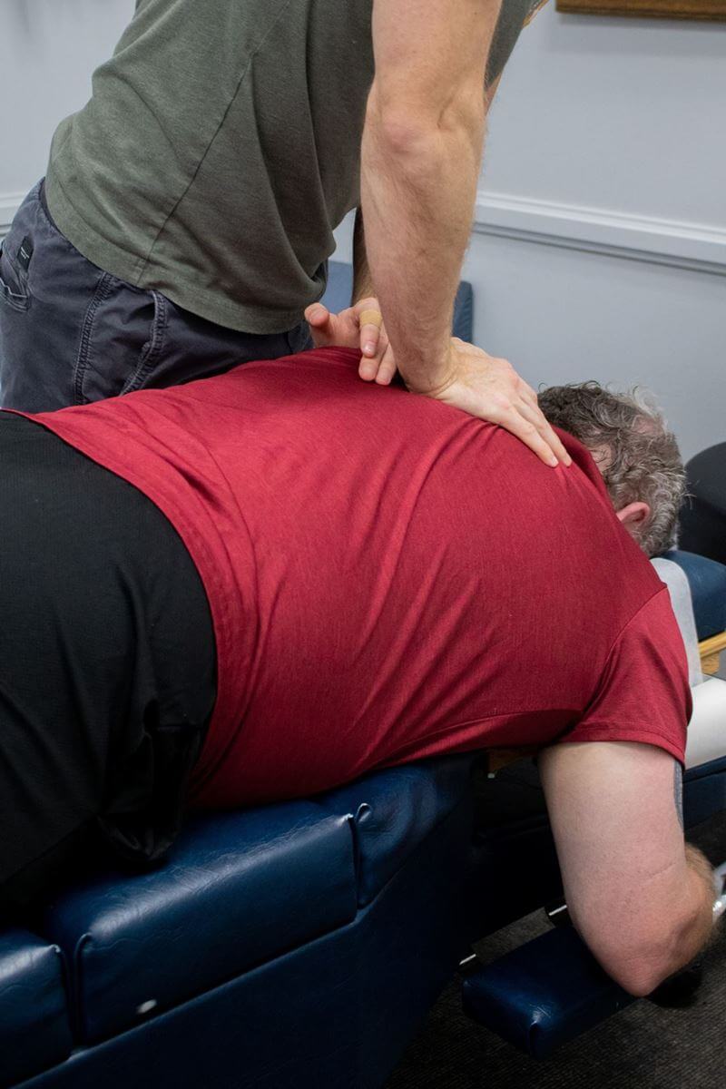 Chiropractor working on a patient's upper back