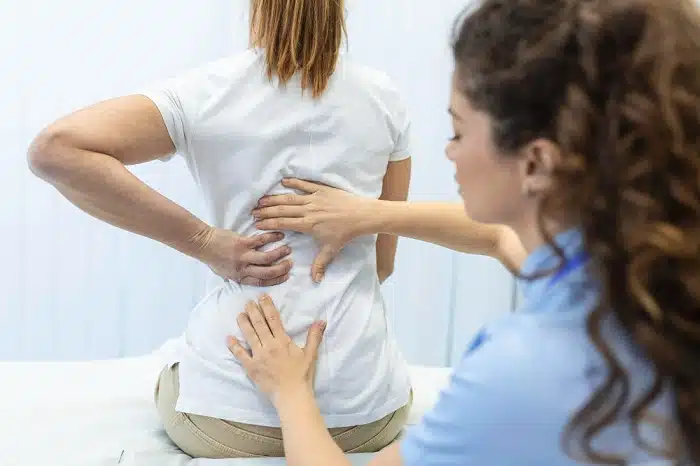 physical therapist doing healing treatment woman spinal stenosis