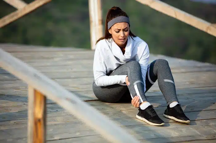 Woman engaged in stretching routine to prevent and relieve shin splint pain.